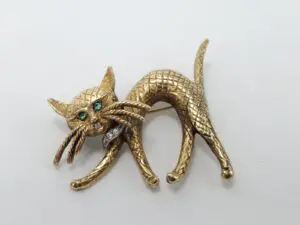 Gold cat brooch with green eyes.