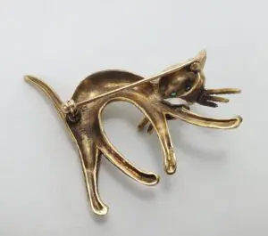 Gold cat brooch with green eyes.