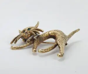 Gold cat brooch with green eyes.