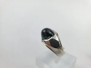 Silver ring with black oval gemstone.