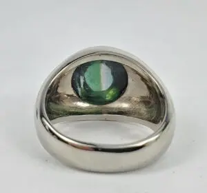 Silver ring with green gemstone centerpiece.