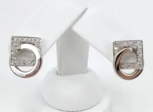 Silver and diamond geometric earrings on display.