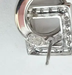 Silver earring with square and circle design.
