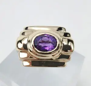 Gold ring with purple gemstone centerpiece.
