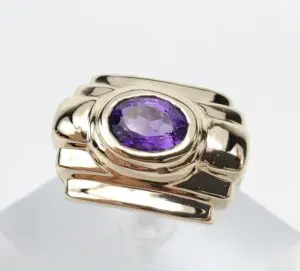 Gold ring with a purple gemstone.