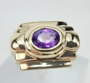 Gold ring with purple gemstone centerpiece.