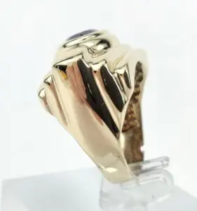 Gold ring with purple gemstone, side view.