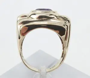 Gold ring with purple gemstone, side view.