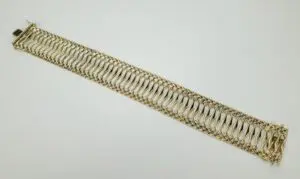 Gold braided bracelet on white background.