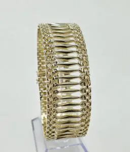 Gold bracelet with intricate geometric design.