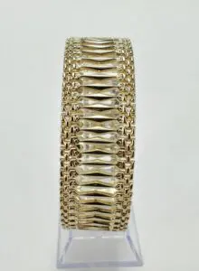 Gold bracelet with intricate woven design.