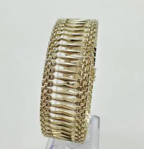 Gold bracelet with intricate geometric design.