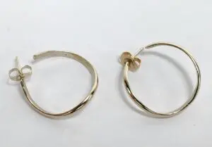 Gold hoop earrings on white background.