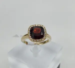 Gold ring with red gemstone and diamonds.
