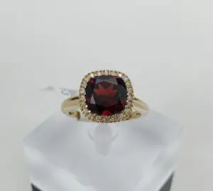 Gold ring with red gemstone and diamonds.