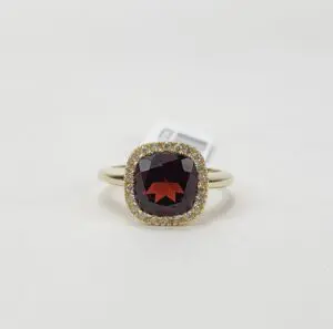 Gold ring with red gemstone centerpiece.