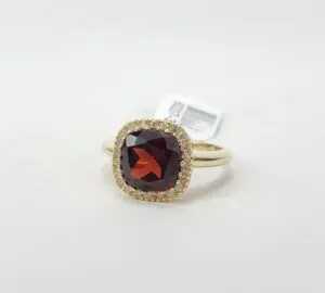 Gold ring with red gemstone and diamonds.