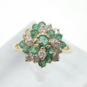 Gold ring with emerald and diamond cluster.