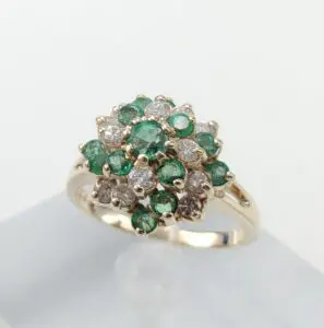Gold ring with emeralds and diamonds cluster.