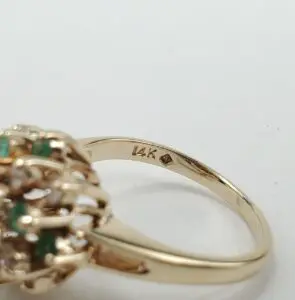 14K gold ring with green stones.