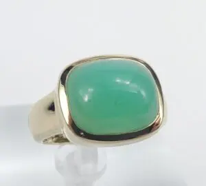 Gold ring with a green gemstone.