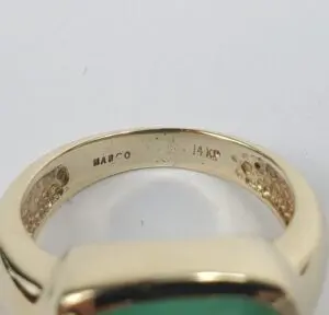 Gold ring with green stone, engraved inside.