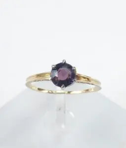 Gold ring with a dark gemstone.