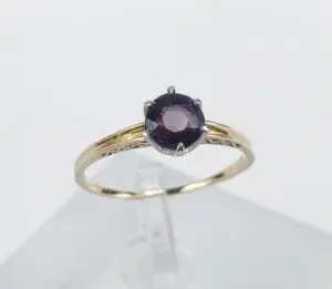 Gold ring with a purple gemstone.