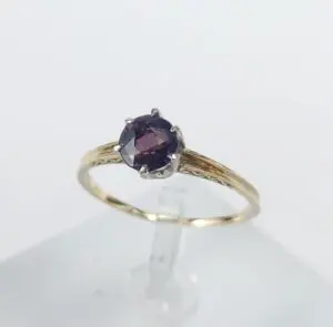 Gold ring with a purple gemstone.