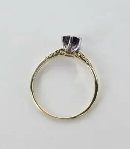 Gold ring with purple gemstone setting.