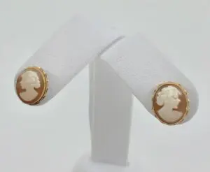 Cameo earrings on white display stand.