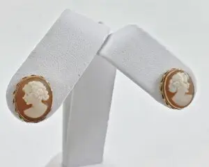 Cameo earrings on white display stand.