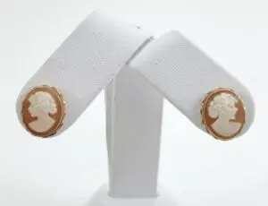 Cameo earrings on white display stand.