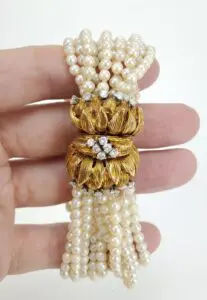 Gold and pearl bracelet in hand.
