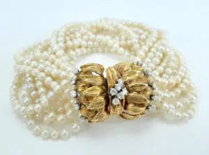 Pearl bracelet with ornate gold clasp.