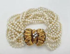 Pearl necklace with ornate gold clasp.
