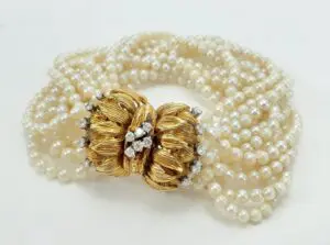 Pearl necklace with ornate gold clasp.
