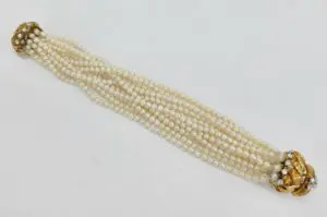 Multi-strand pearl necklace with gold clasps.