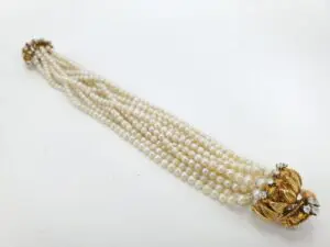 Pearl necklace with gold and diamond clasp.