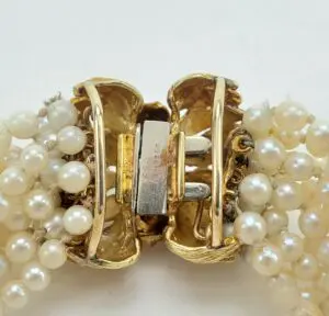 Gold clasp with pearl strands.