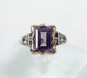 Gold ring with large purple gemstone.