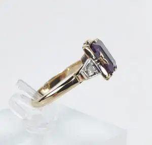 Gold ring with purple gemstone and diamond.