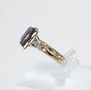 Gold ring with purple gemstone and diamond.