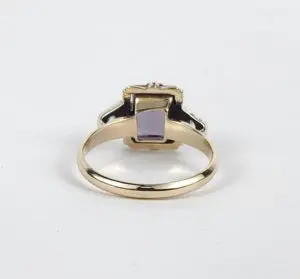 Gold ring with a purple gemstone.