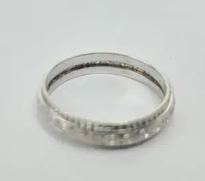 Silver ring with intricate engraved design.