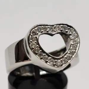 Silver ring with heart-shaped diamond design.
