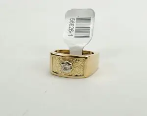 Gold ring with diamond and price tag.