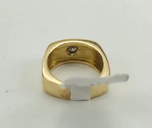Gold ring with a gemstone inside band.