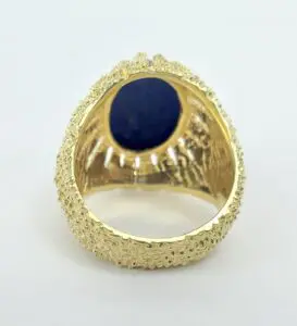 Gold ring with blue oval gemstone.