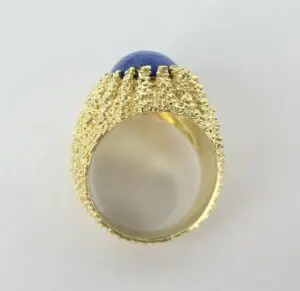 Gold textured ring with blue gemstone.